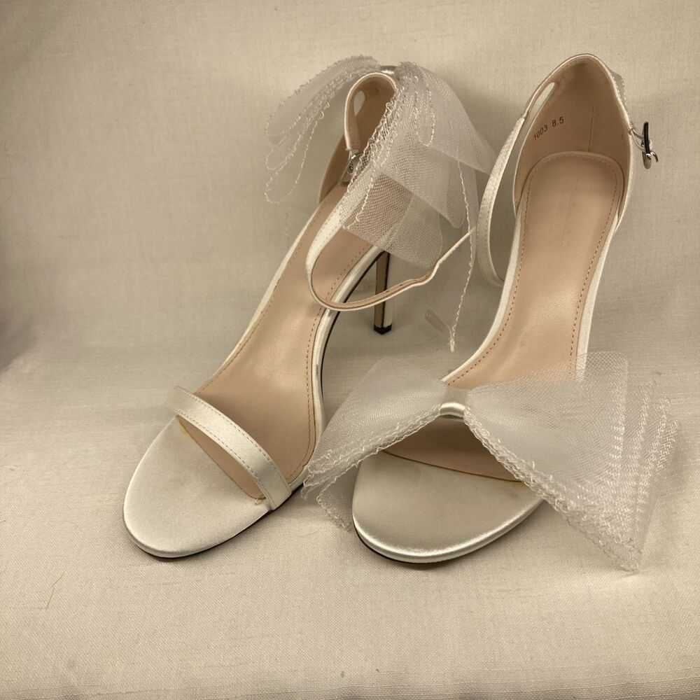 Ivory Ankle Strap Tulle Bow Heels feature a 4.25-inch stiletto heel, an adjustab